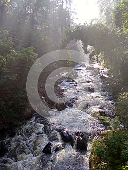 Water river with bright sun in the middle of the forest tahura curug omas waterfall stone rock