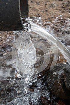 Water running out of plastic pipe at winter