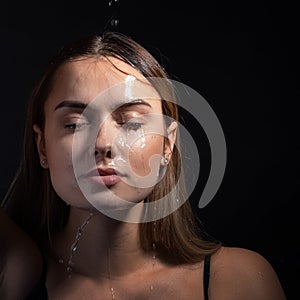 Water runs down my face. Portrait of a young beautiful woman.