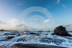 Water rushiing over rock on shelly beach