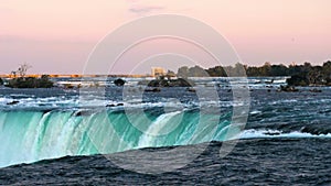Water rushing over Horseshoe Falls, Niagara Falls, Ontario, Canada. Sunset.