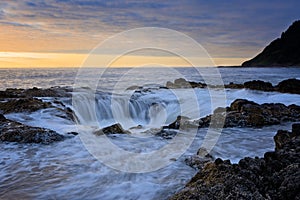 Water rushing into Thor`s Well during dramatic sunset Cape Perpetua Oregon