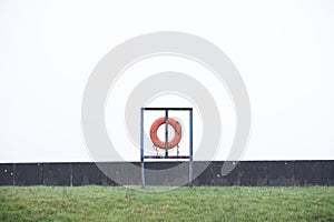 Water safety red ring buoy hanging at sea harbour wall art