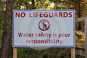 Water Safety sign stating no lifeguards on duty and to take care while swimming in the lake