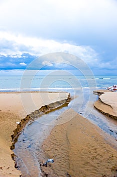 Water and sand on the shoreline in Follonica, Italy