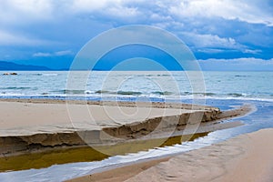 Water and sand on the shoreline in Follonica, Italy