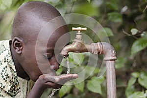 Water scarsity in the world symbol. African boy begging for water. In places like sub-Saharan Africa, time lost to gather water photo