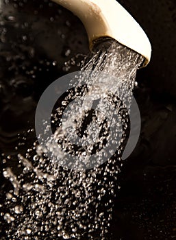 Water from the shower on the black background