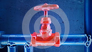 Water shut-off red valve on a blue metal pipe