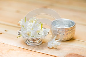 Water in silver bowl with Jasmine flower.