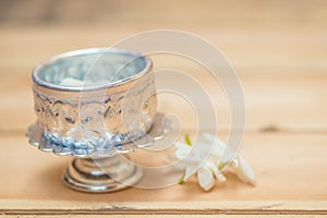 Water in silver bowl with jasmine white flower.