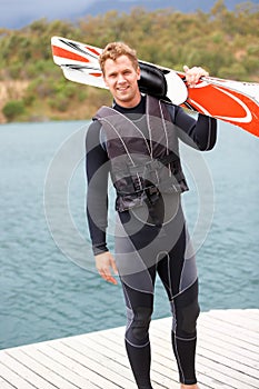 Water ski, portrait and man by lake with wakeboard for surfing, exercise and recreation hobby outdoors. Fitness, extreme