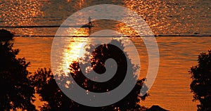 Water skier during golden hour - orange reflection of sun