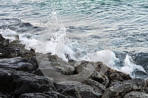Water slashing onto beach rocks.