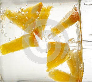 Water and slices of orange as a background.Fresh cold drink