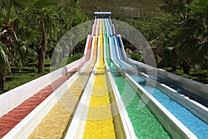 Water slide with bright colored tracks in the aqua park surround