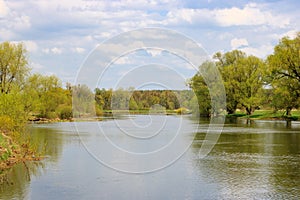 Water smooth surface of a river against a blue sky. Natural landscape