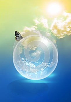 The water in a soap bubble is a concept of water conservation, with butterflies on top of it and a backdrop of the sky and the