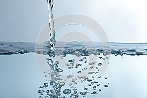 Water splash. Aqua flowing in waves and creating bubbles. Drops on the water surface feel fresh and clean.