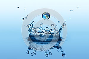 Water splash in crown shape and falling drop with earth image