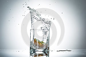 Water splash in glass of gray color