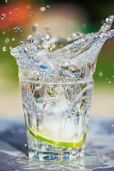 Water splash in glass on table in garden