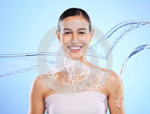 Water splash, portrait and woman shower in studio, blue background and healthy beauty of wellness skincare. Happy female