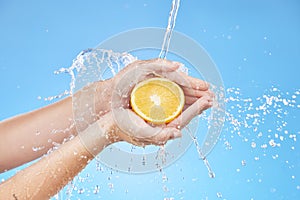 Water splash, zoom or orange in hands for skincare wellness, nutrition or health in blue background studio. Water