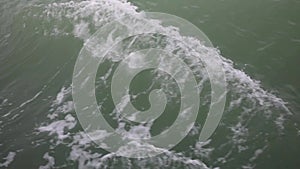 Water splashes foamy trace of motor boat on calm water closeup. Foamy track on sea surface behind motorboat