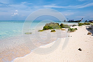 Water splashing. Crystal clear sea water beating against the rocks . Blue sky above the beach in the sun refreshing drops