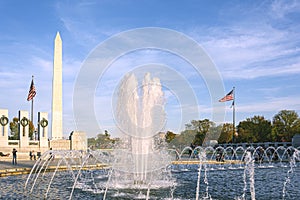 Water splashing from the fountain at the World War II memorial with the Washington Monument in the background in the National Mall