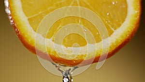 Water splashing on fresh orange in slow motion. Water dropping from citrus fruit. Close up orange slice rich in vitamin