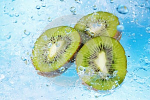 Water splashing on kiwi slices