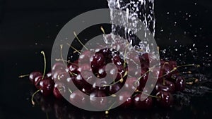 Water splashing on ripe, juicy cherries