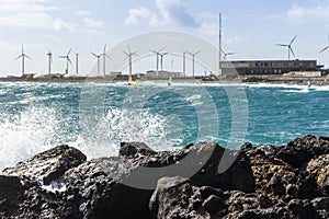 Water splashing on the rocks with windsurfers in the background, Pozo Izquierdo, Gran Canaria, Spain photo