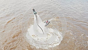 Water sports - a man training flying over the water on the flyboard - aerial view