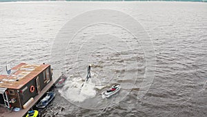 Water sports - a man training flying over the water on the flyboard near an island - aerial view