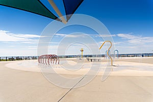 Water spraying on a fun splashpad with lake in the distance