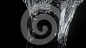 Water spurting out against black background,