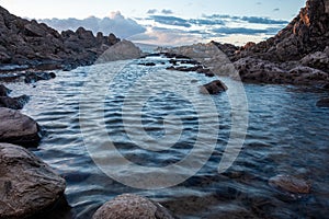 Water with stones in it sorounded with rocks