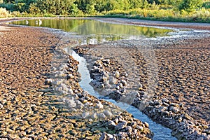 Water stream flows into the pond shrinking