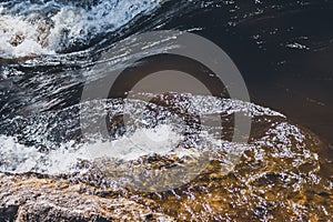 Water stream with foam. falling river water. waterfall flow. abstract water background