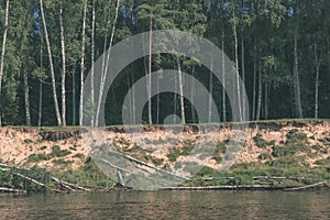 water stream in river of Amata in Latvia with sandstone cliffs, green foliage - vintage retro film look