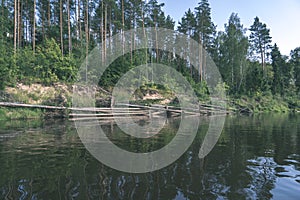 water stream in river of Amata in Latvia with sandstone cliffs, green foliage - vintage retro film look