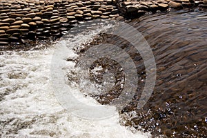 Water streams of an artificial stream among pebbles