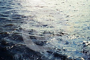 Water surface with ripples and sunlight reflections