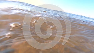 Water surface sea, transparent water waves ripples sand bottom stones and shells