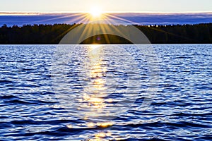 Water surface. View of a Sunset sky background. Dramatic gold sunset sky with evening sky clouds over the sea. View of a Crystal c