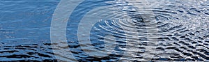 Water surface and water drop with waves of water in sun light and sky reflection background