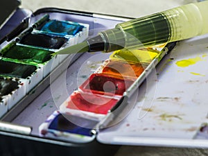 Water tank brushes on watercolor paint box